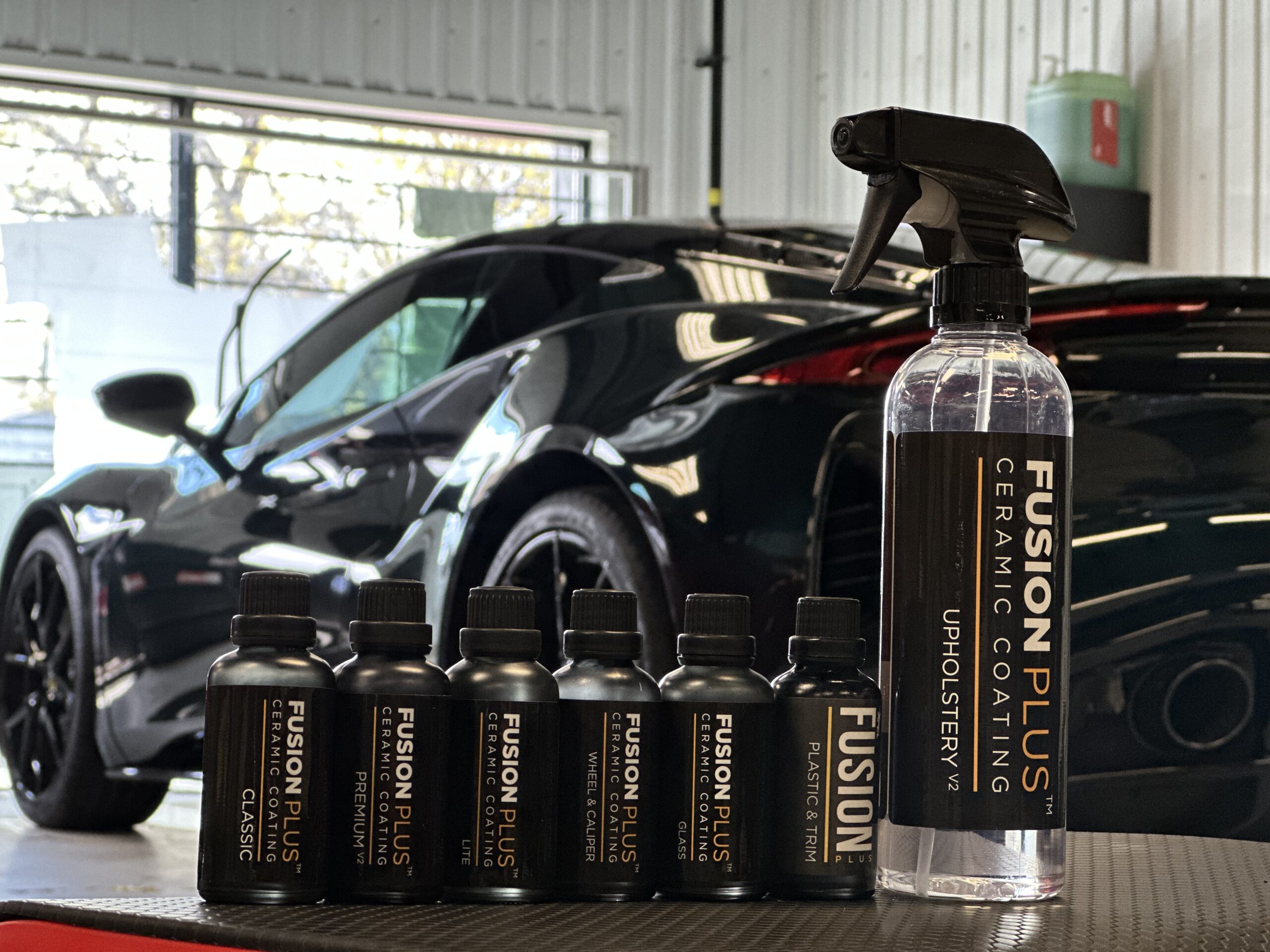 A lineup of professional XPEL Fusion Plus ceramic coating bottles and surface prep products in an Ottawa detailing shop.
